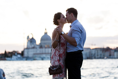 Russian couple kissing during an engagement photo service with the background of san Giorgio island.