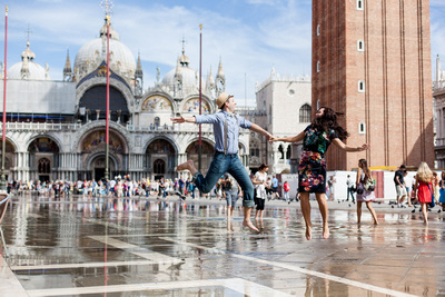 couple jumping in San Marco square during a honeymoon photo service in Venice