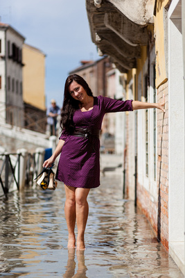 Russian bride waliking barefoot in high water during a honeymoon photo shooting in Venice