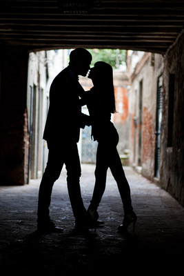 Russian couple kiss under an arcade during a honeymoon photo service in Venice 